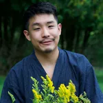 The author, wearing a jinbei, holding flowers